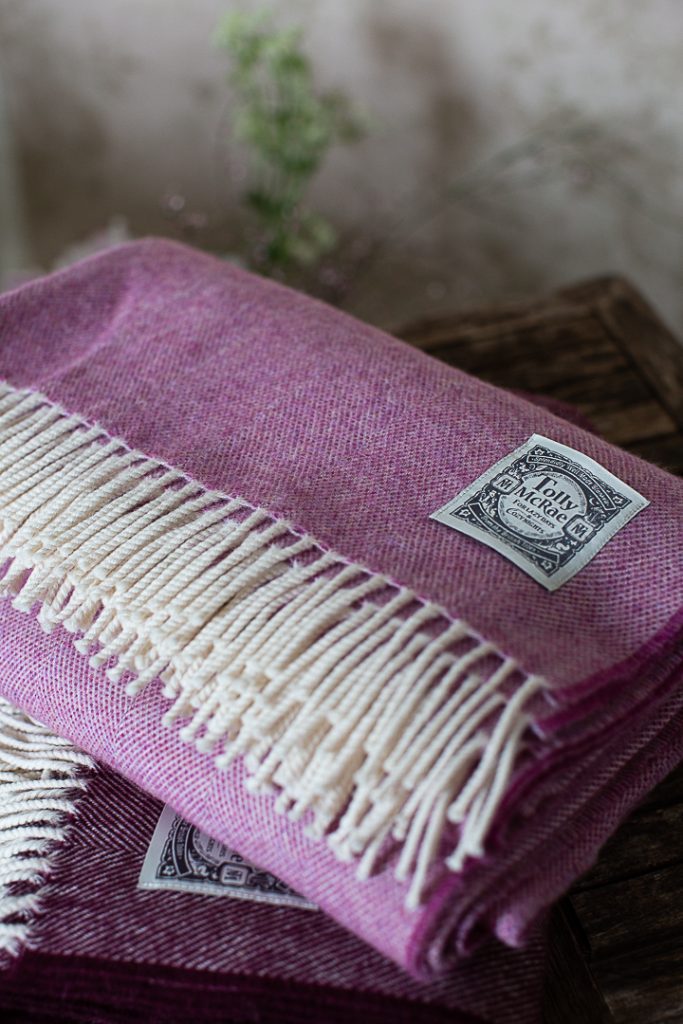 Raspberry pink wool throw with a cream fringe edging