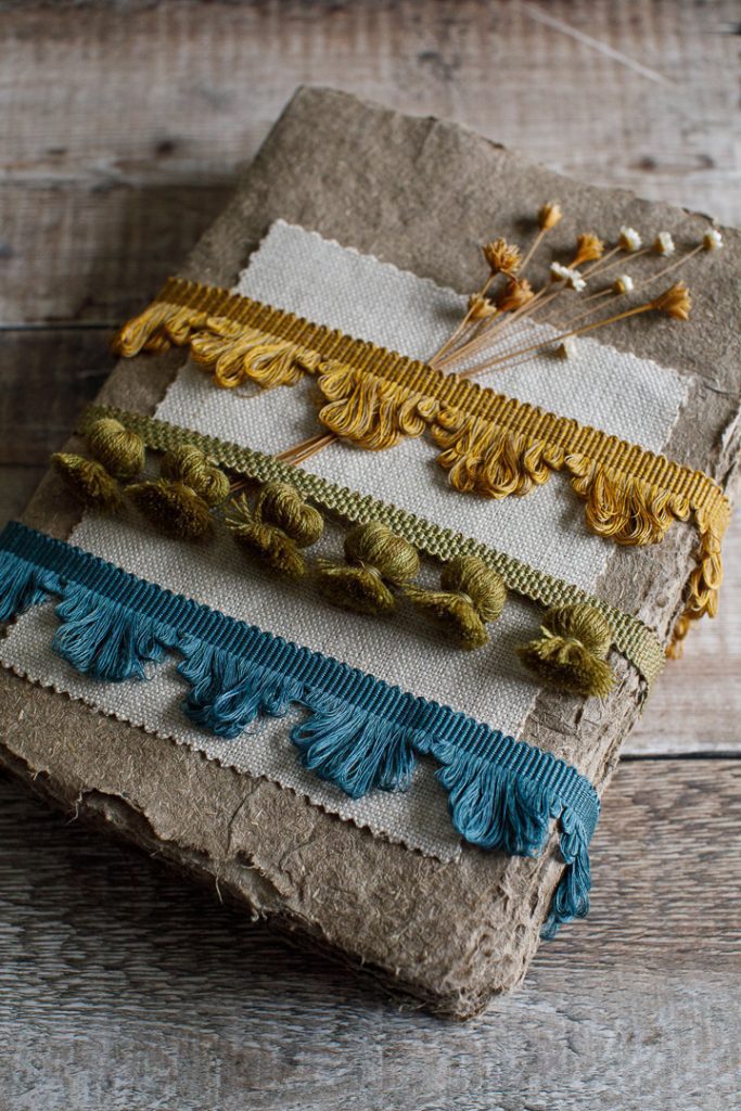 A mix of fan edge trimmings and onion tassel trimmings on a linen background